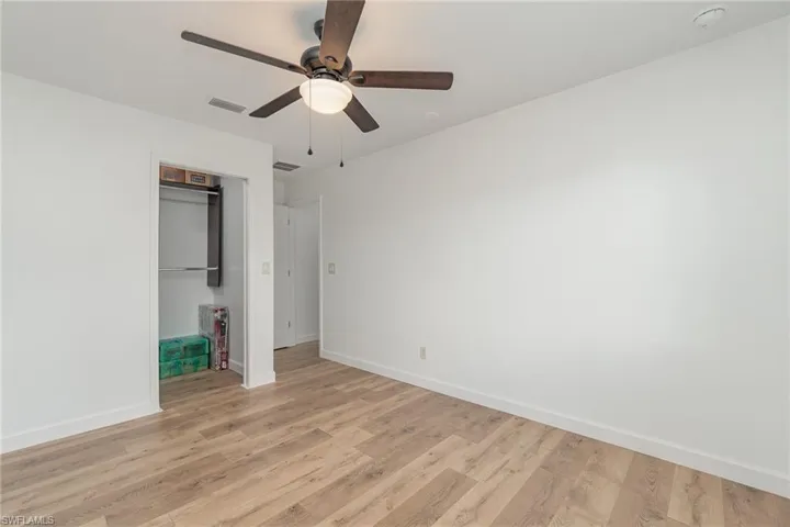 Unfurnished bedroom featuring light wood-type flooring, ceiling fan, and a closet
