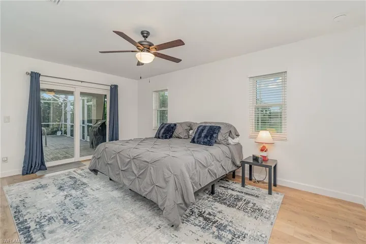 Bedroom with ceiling fan, light hardwood / wood-style floors, and access to outside