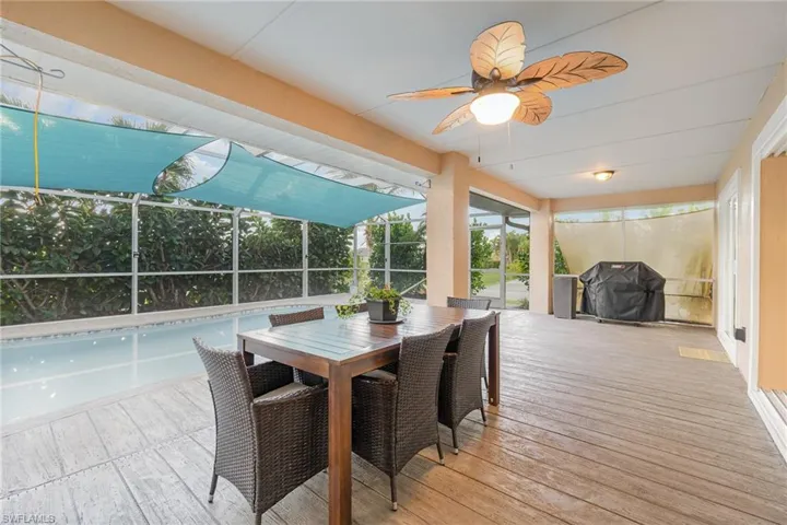 Lanai featuring a shaded pool, privacy landscaping, and ceiling fan