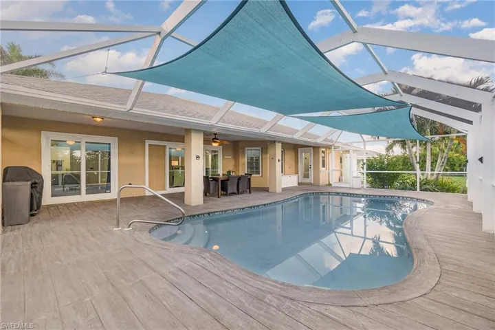 View of swimming pool with a lanai, a patio, ceiling fan, and a concrete wood like pool deck