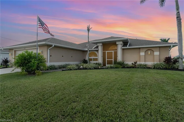 View of front of house with a lawn and 2 car garage