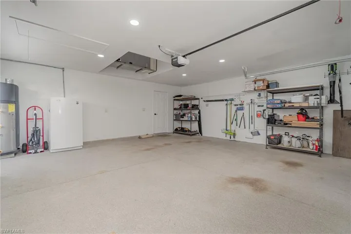 Garage with a smart garage door opener, energy efficient electric water heater, and shelving/storage