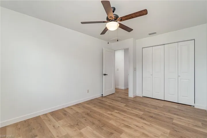 Unfurnished bedroom with ceiling fan, light wood-type flooring, and a closet
