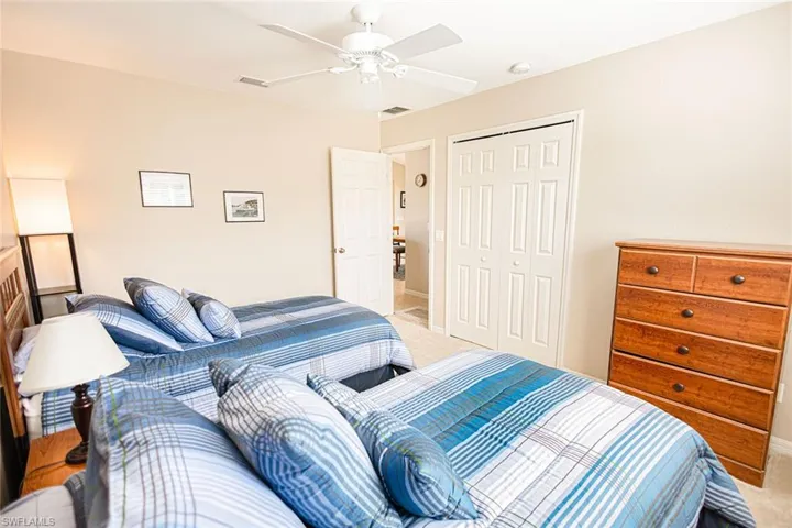 Bedroom featuring ceiling fan, a closet, and light colored carpet