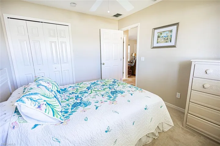 Bedroom with light colored carpet, a closet, and ceiling fan