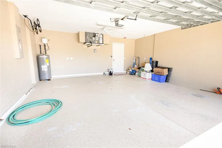 Garage featuring a garage door opener and water heater