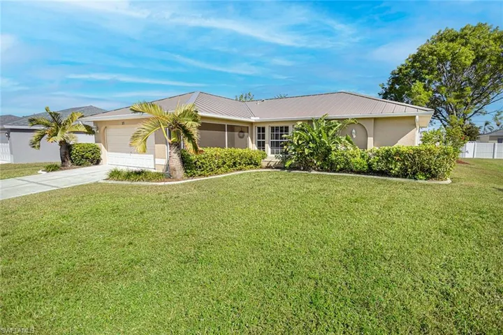 Single story home with a garage and a front lawn
