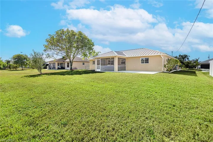 Rear view of property featuring a yard and a patio