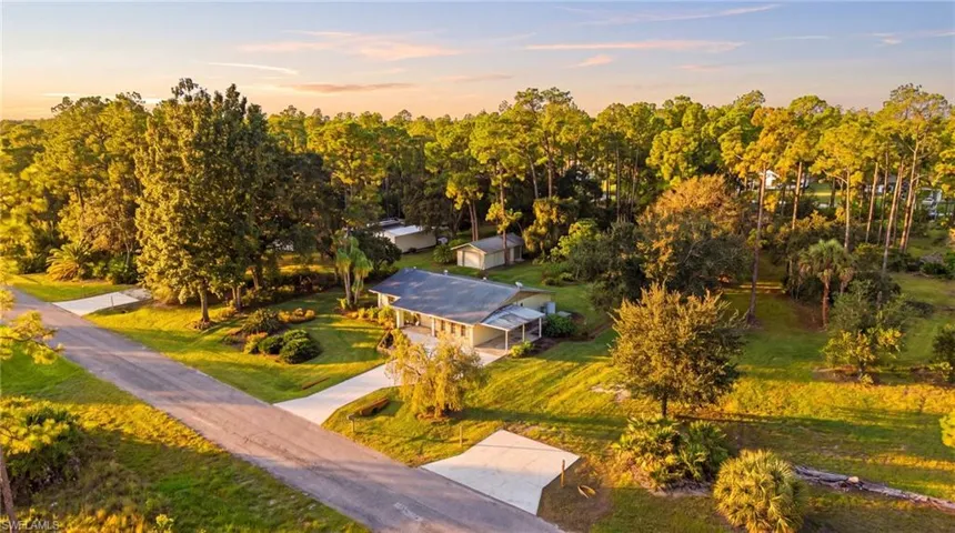 Single-story residence featuring a shingle roof, covered entryway, concrete driveway, and established landscaping situated on a spacious, wooded lot