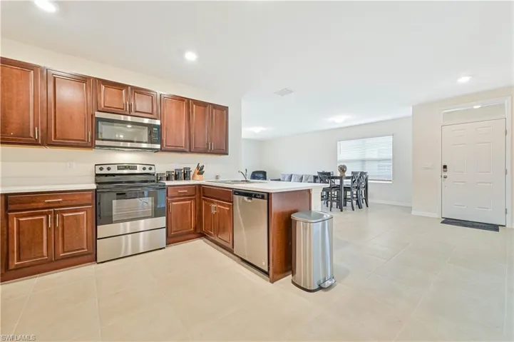Kitchen featuring sink, light tile patterned flooring, kitchen peninsula, and stainless steel appliances