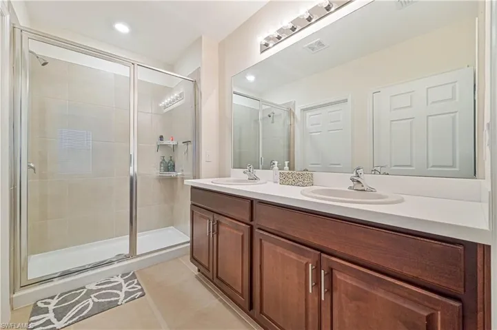 Bathroom featuring vanity, a shower with shower door, and tile patterned floors