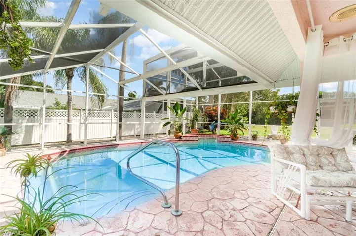 View of swimming pool featuring glass enclosure, a patio area, and a sunroom