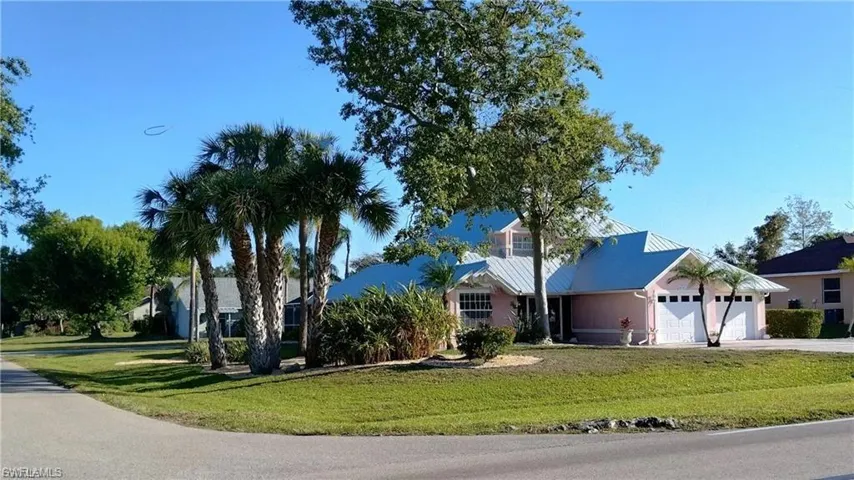 View of front of house featuring a front yard, a garage, and driveway
