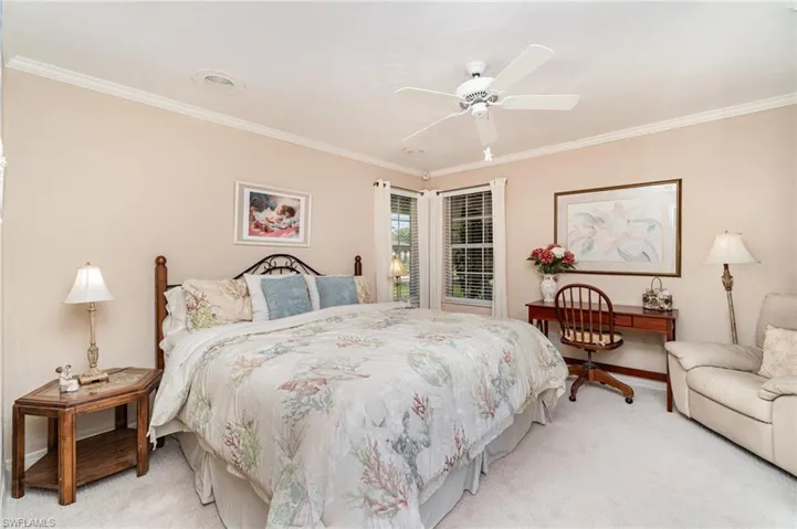 Bedroom with crown molding, light colored carpet, and ceiling fan