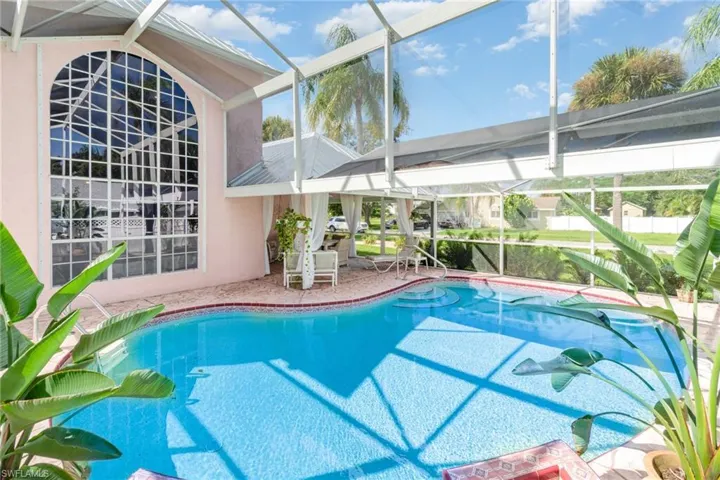 Swimming pool with a sunroom, a lanai, and a patio