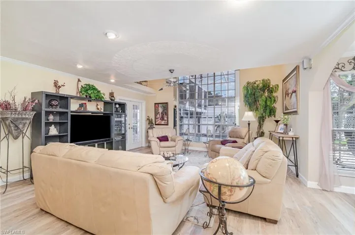 Living room with crown molding, light wood-type flooring, healthy amount of natural light, ceiling fan, and recessed lighting