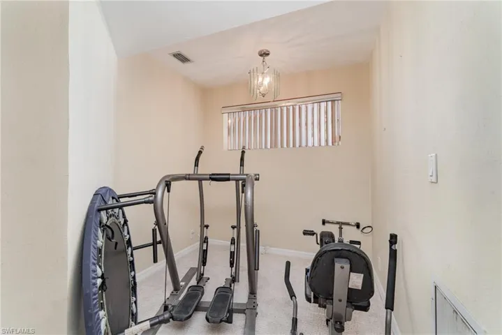 Exercise area featuring carpet and a chandelier