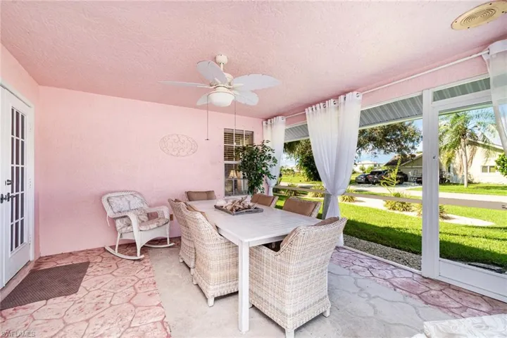 Sunroom featuring french doors, outdoor dining space, a ceiling fan, and a patio