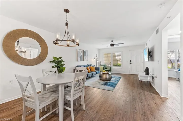 Dining room with a chandelier, light wood finished floors, plenty of natural light, and a ceiling fan