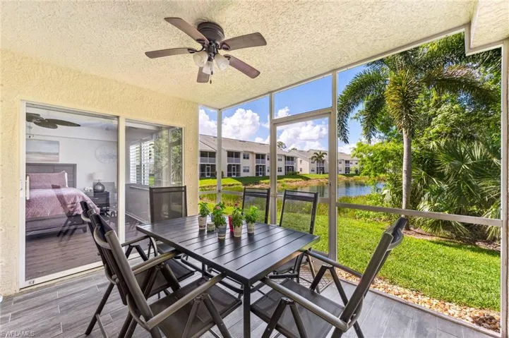 Sunroom with a water view, ceiling fan, and outdoor dining area