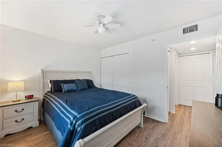 Bedroom featuring light wood-style floors, ceiling fan, and a closet