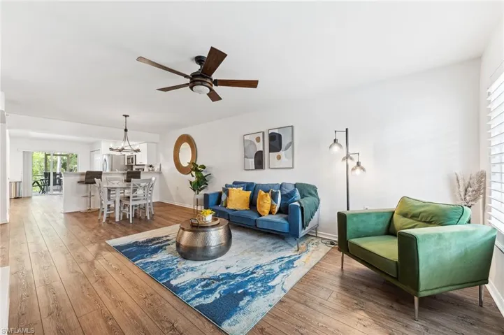 Living area featuring a ceiling fan, hardwood / wood-style floors, and a chandelier