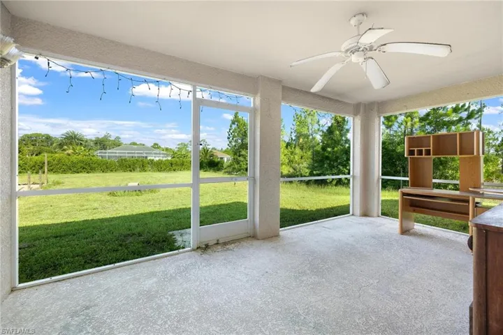 Unfurnished sunroom featuring ceiling fan