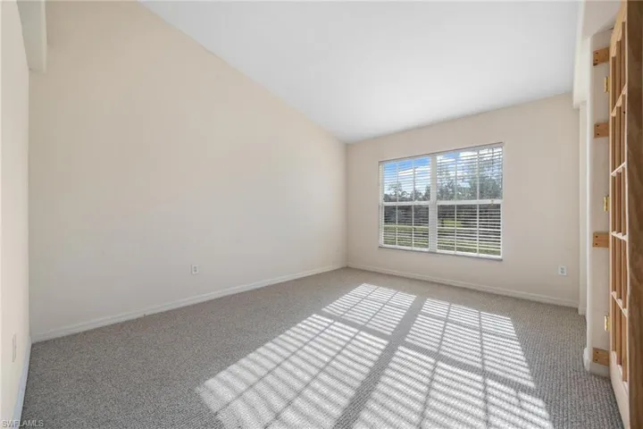Spare room with lofted ceiling and carpet flooring