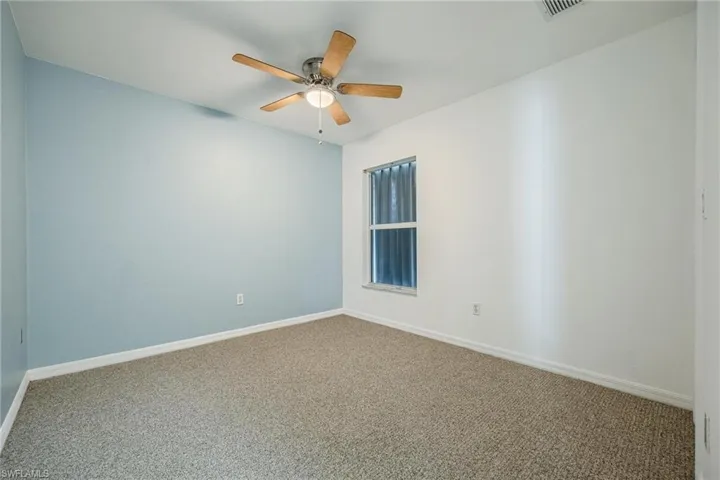 Carpeted empty room with ceiling fan