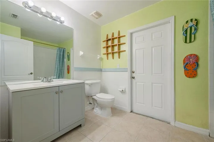 Bathroom featuring vanity, tile patterned flooring, and toilet