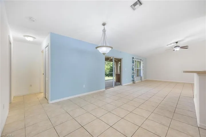 Empty room with light tile patterned flooring and ceiling fan