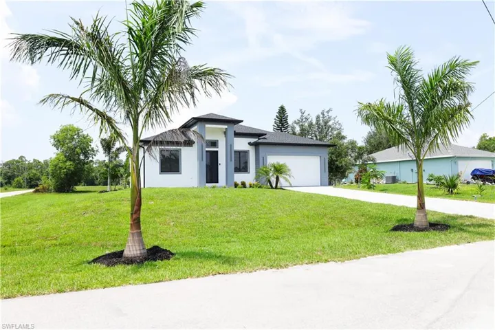 View of front of house featuring a garage and a front yard