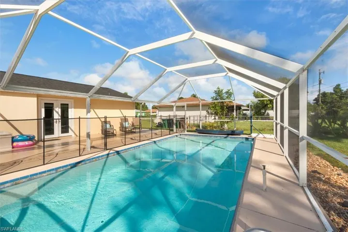 Outdoor pool featuring french doors, a lanai, a sunroom, and a patio
