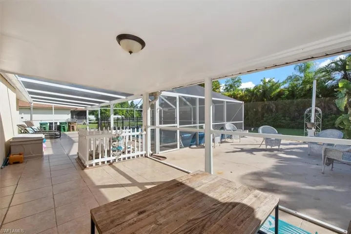 View of patio with glass enclosure, a sunroom, and a swimming pool