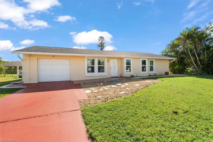 Single story home featuring a front lawn, stucco siding, driveway, and an attached garage