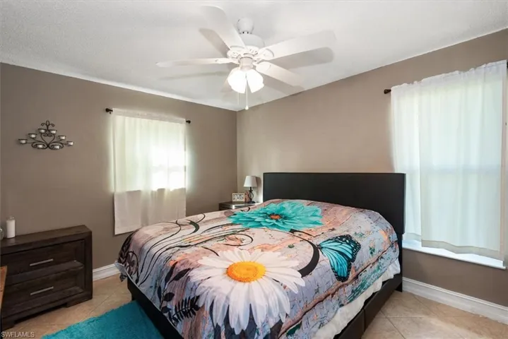 Bedroom featuring light tile patterned floors, a textured ceiling, and ceiling fan