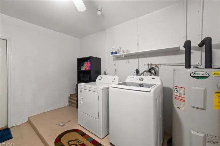 Laundry room featuring water heater and separate washer and dryer