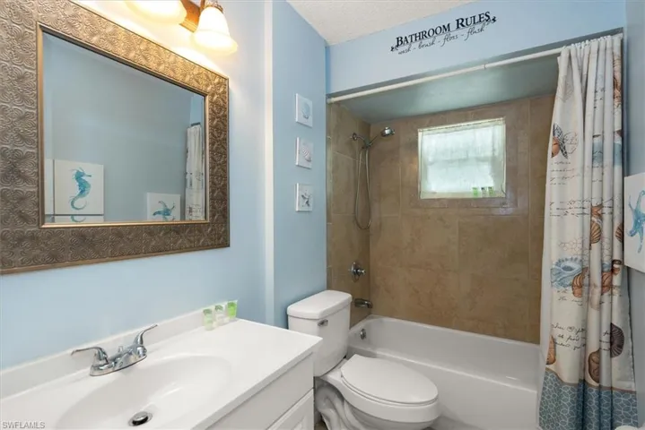 Full bath featuring shower / bath combination with curtain and vanity