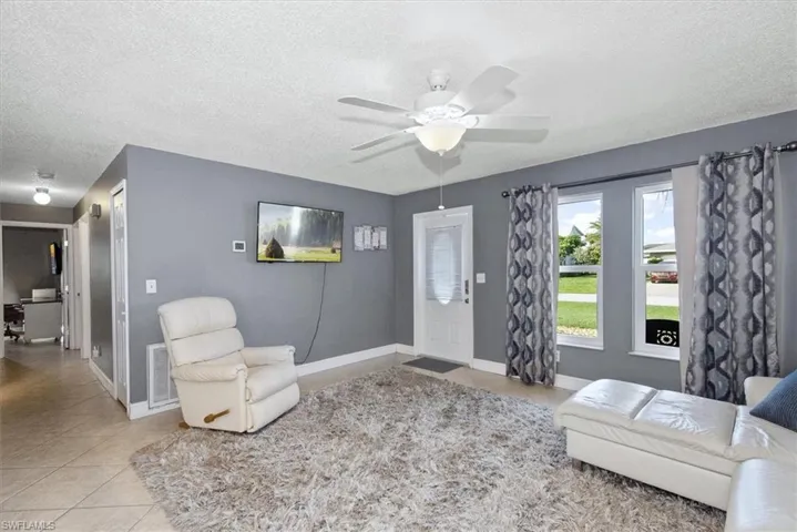 Foyer with a textured ceiling, tile patterned flooring, and a ceiling fan