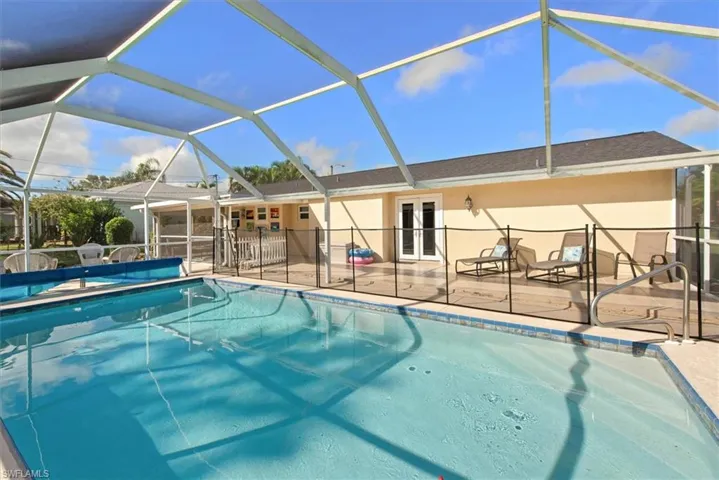 Swimming pool with a lanai, french doors, a sunroom, and a patio