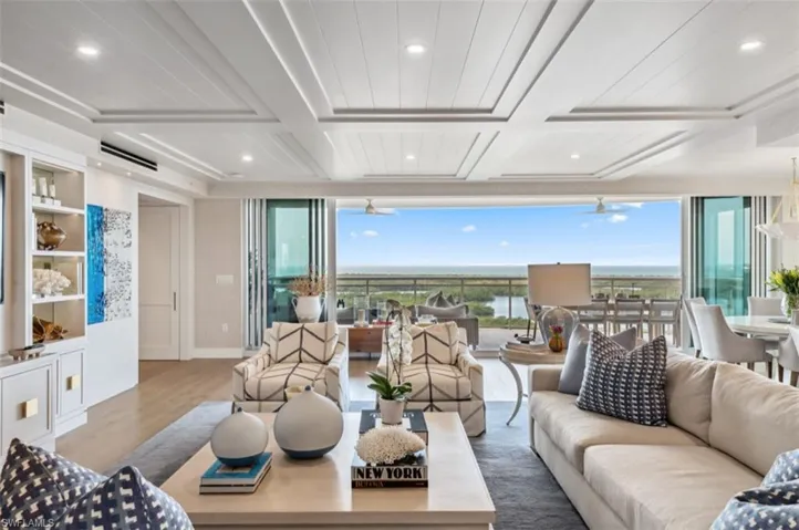 Living room featuring coffered ceiling, wood finished floors, recessed lighting, beam ceiling, and a ceiling fan