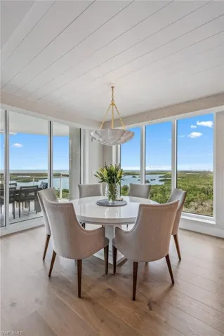 Dining area with light wood-style floors, healthy amount of natural light, and a water view