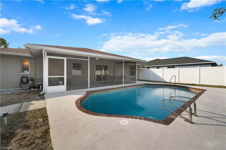 View of swimming pool featuring a sunroom and a patio