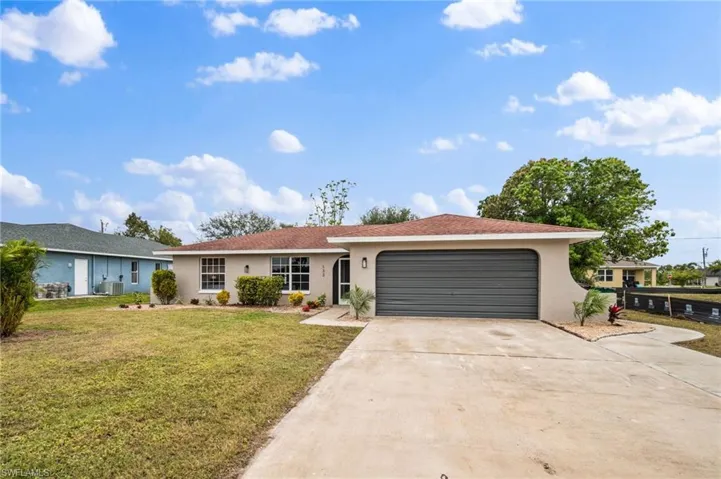 Ranch-style house with cooling unit, a front lawn, and a garage