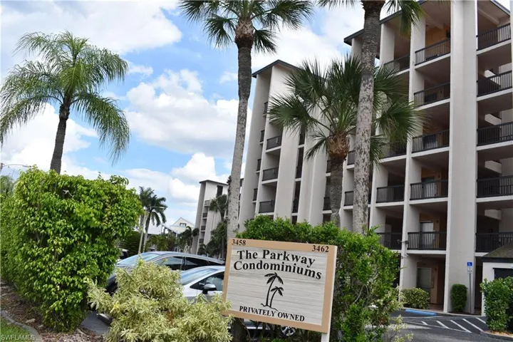 Multi-story condominium building featuring numerous private balconies with black railings