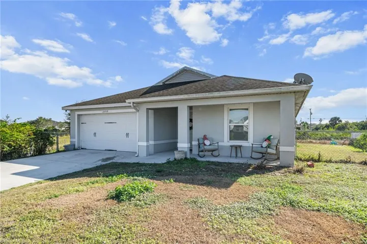 View of front of property featuring stucco siding, a shingled roof, driveway, a garage, and a porch