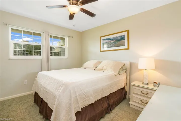 Bedroom with ceiling fan and light colored carpet