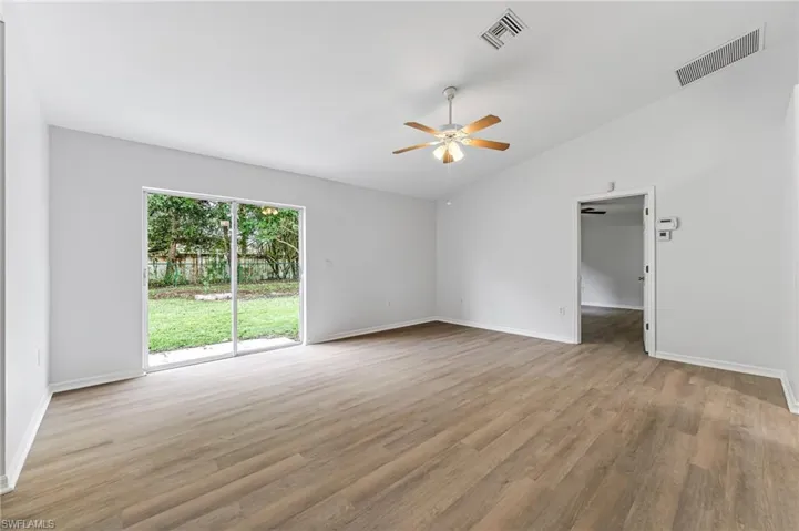 Spare room featuring lofted ceiling, ceiling fan, and hardwood / wood-style floors