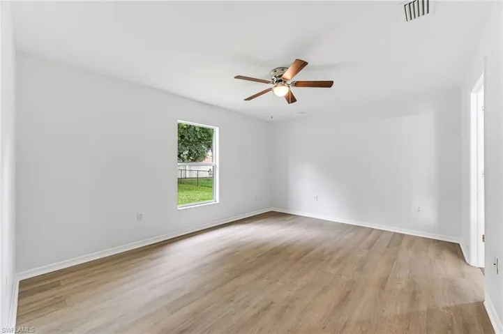 Empty room with ceiling fan and light hardwood / wood-style flooring