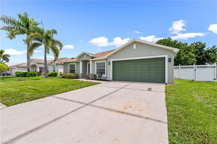 Ranch-style house with a front yard and a garage